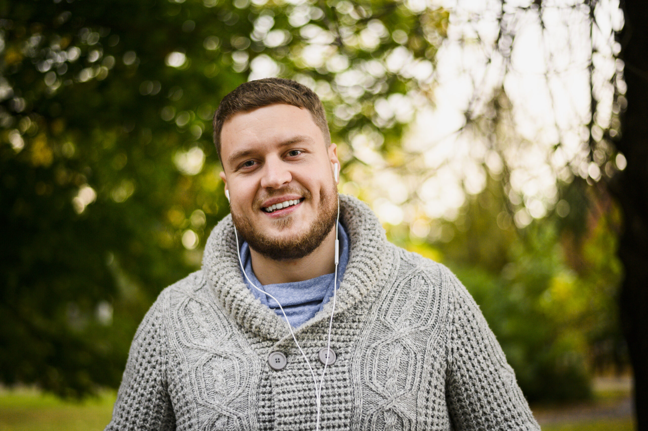 happy-man-with-earphones-smiling-camera